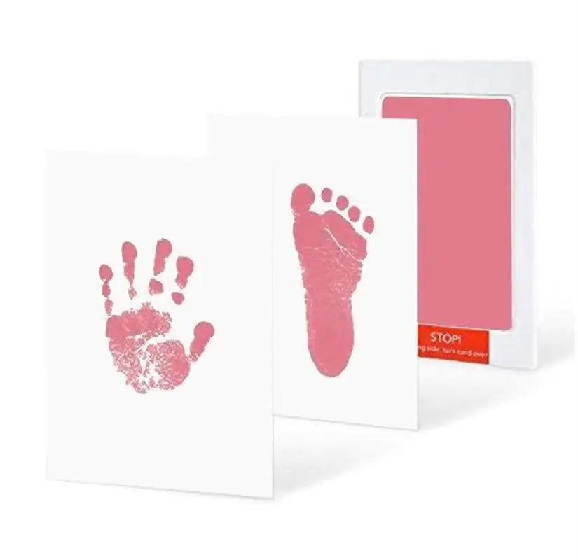 Pink no-ink baby hand and foot print kit with two white cards displaying prints.