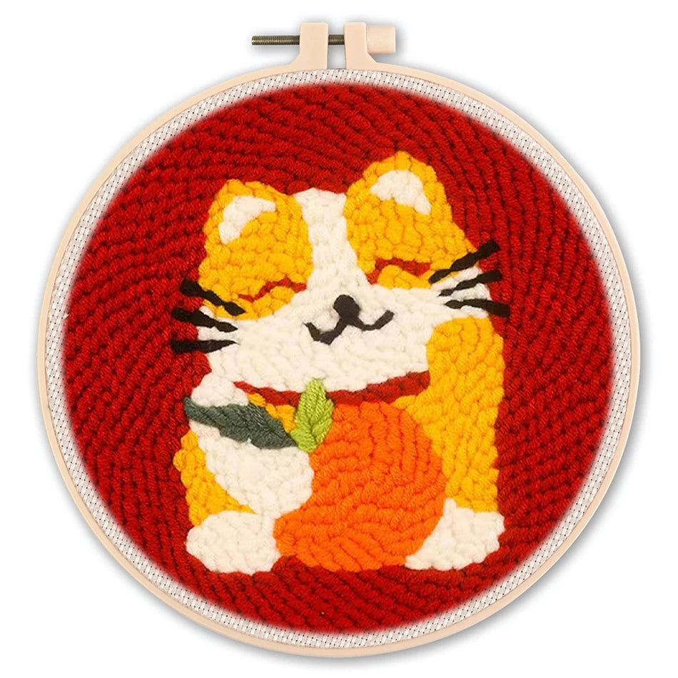Punch needle embroidery kit featuring a cute orange and white cat holding a pumpkin on a red background.