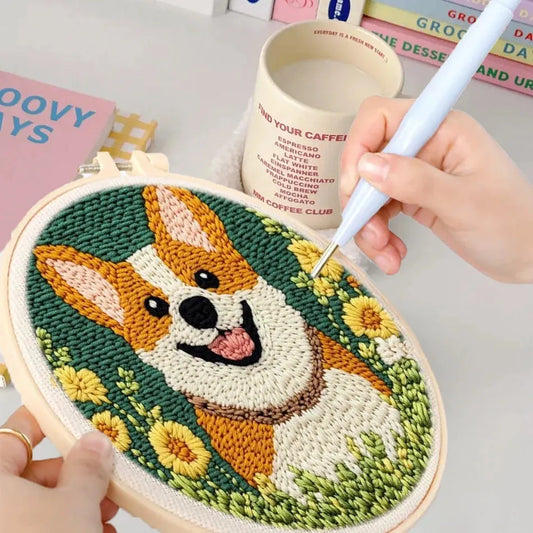 Punch needle embroidery kit with a cute corgi design, green background, and yellow flowers in an oval hoop.