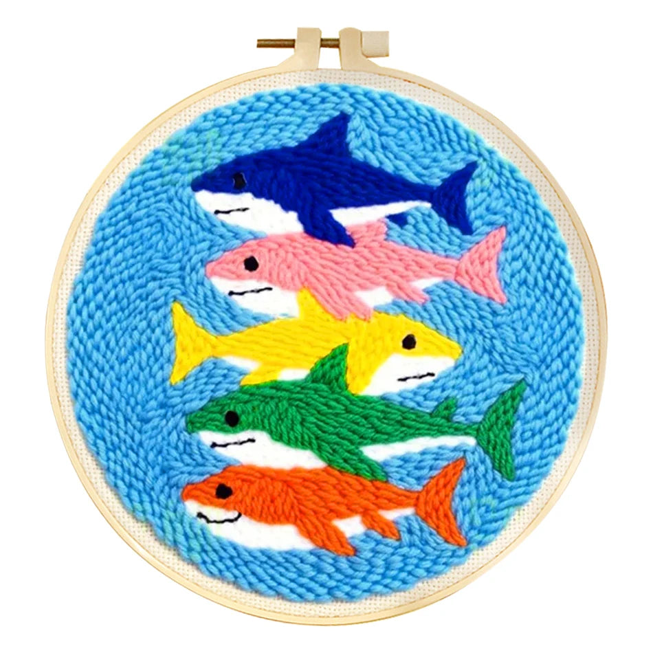 Punch needle embroidery kit with colorful shark design in a wooden hoop.