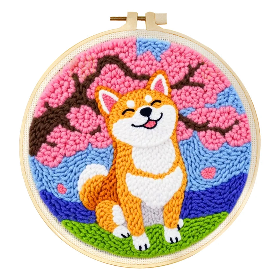 Punch needle embroidery kit with a happy Shiba Inu and pink cherry blossoms in a wooden hoop.