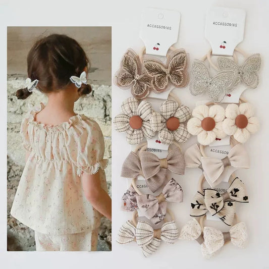 Girls' 10-pack elastic hair ties with embroidered butterflies, plaid flowers, and floral bows.