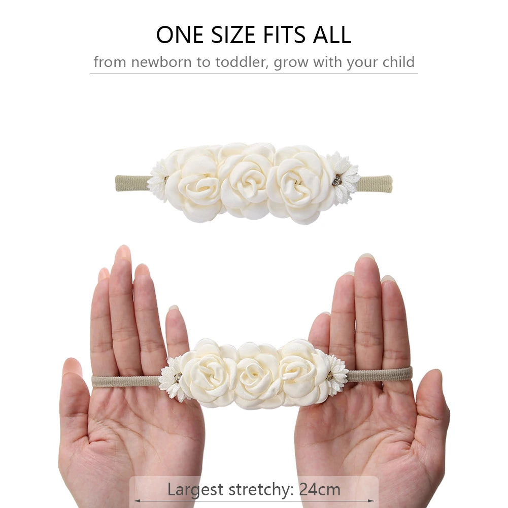 Soft nylon baby headband with cream floral design, shown stretched between hands.