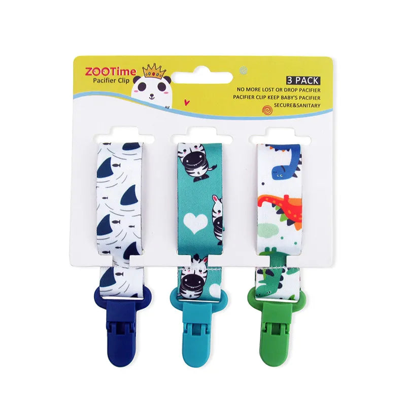 3-pack of ZOO Time pacifier clips with shark, zebra, and dinosaur patterns, featuring plastic clips.