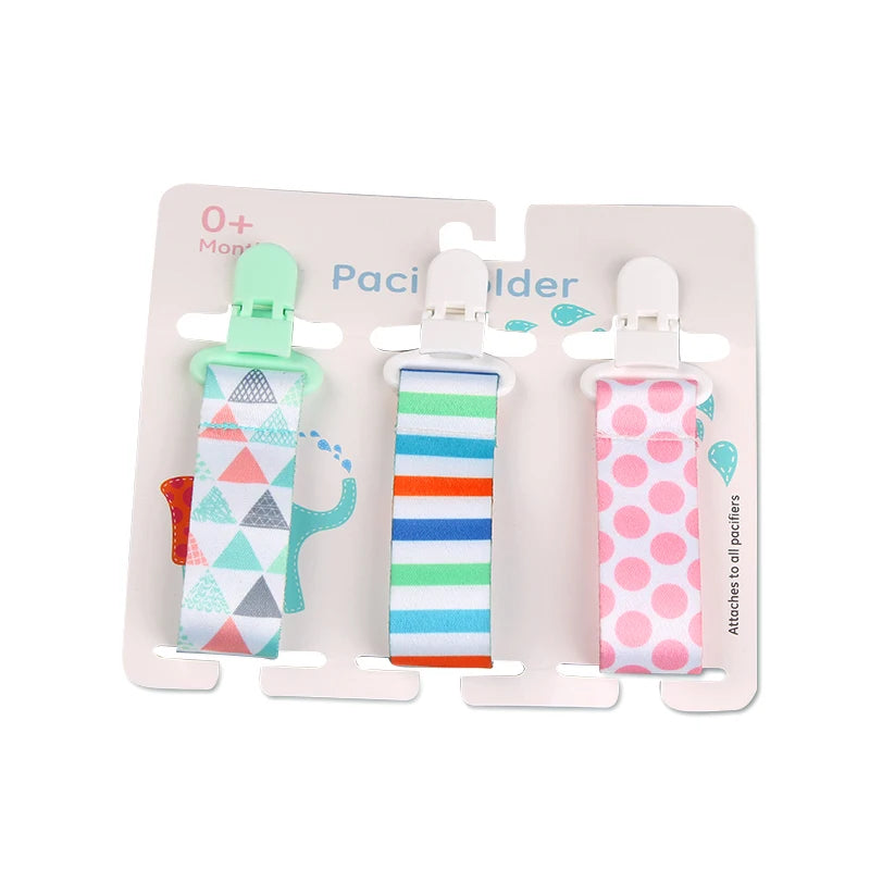 Set of 3 polyester pacifier clips with plastic clasps: one with colorful triangles, one with blue, orange, and green stripes, and one with pink polka dots.