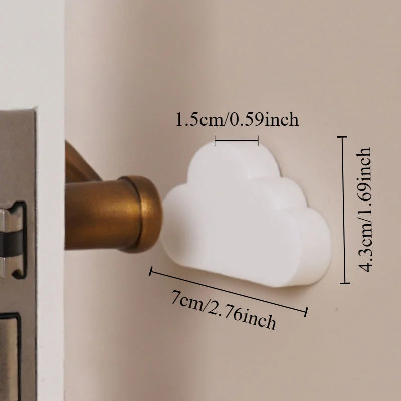 White cloud-shaped silicone door stopper with dimensions 7cm x 4.3cm x 1.5cm, next to a bronze door handle.