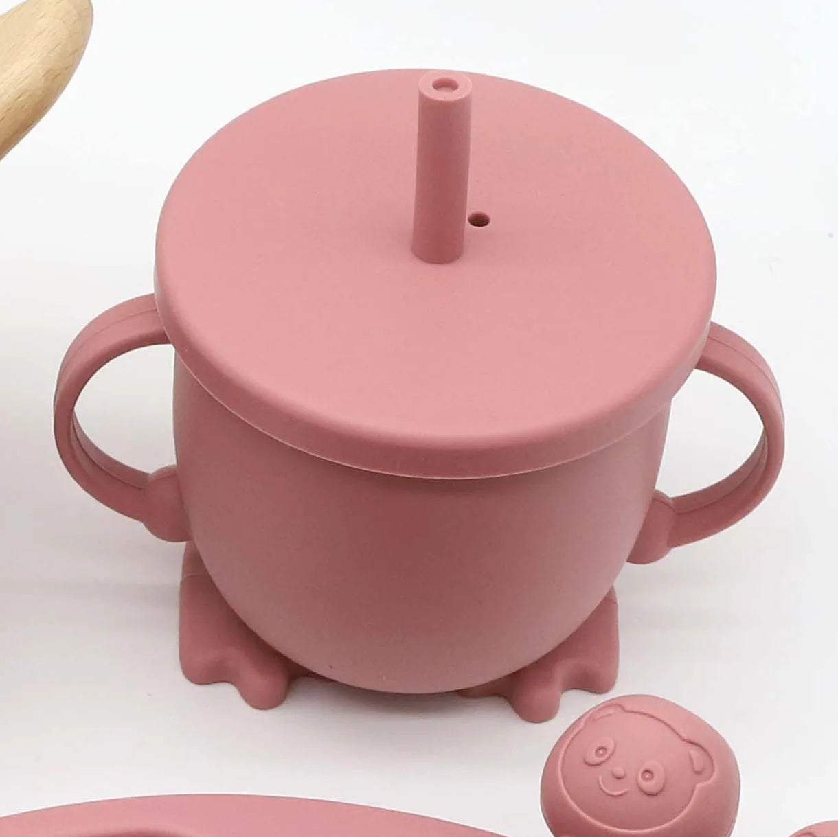 Pink silicone baby sippy cup with handles, lid, and straw, part of an 8-piece feeding set.