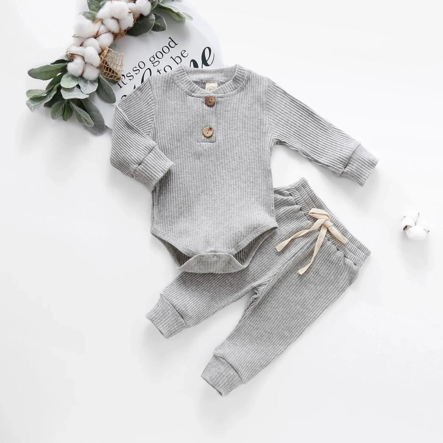 Gray ribbed cotton long-sleeve baby bodysuit and pants set with wooden buttons and drawstring.