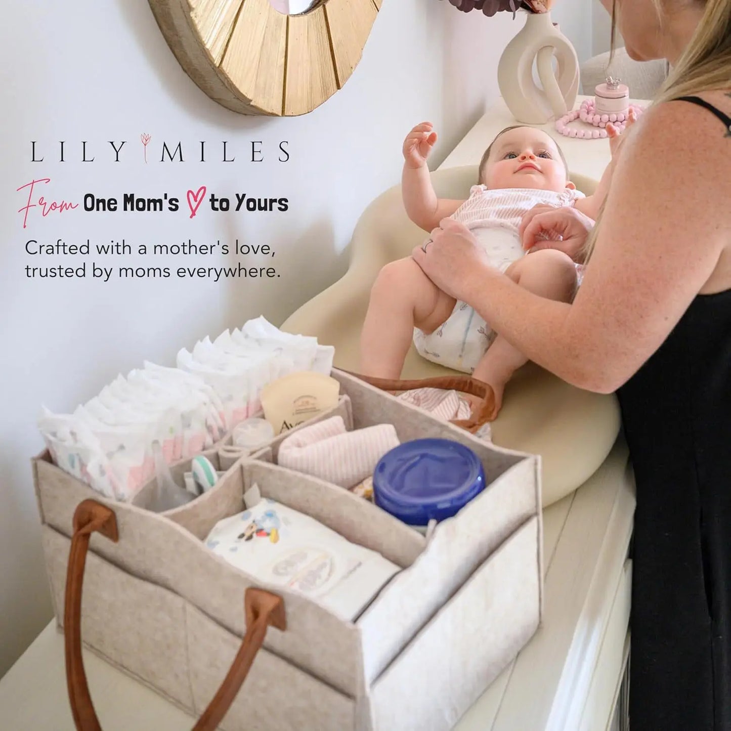 Beige felt diaper caddy with brown handles, organized with baby essentials next to a changing baby.