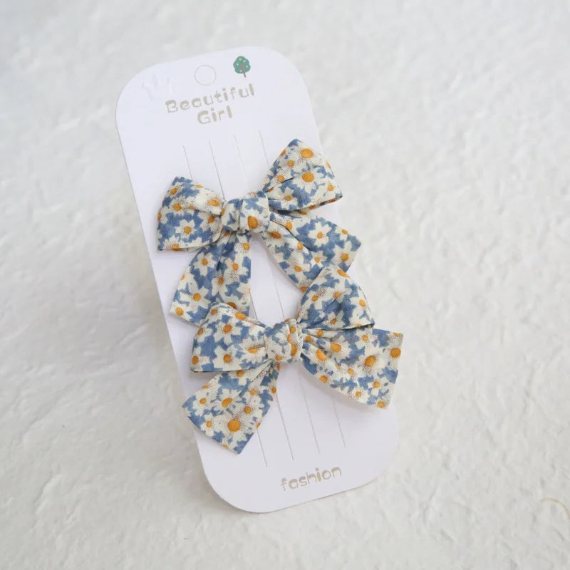 Two blue and white floral cotton hair bows for girls, 7.5cm, on a white "Beautiful Girl" card.