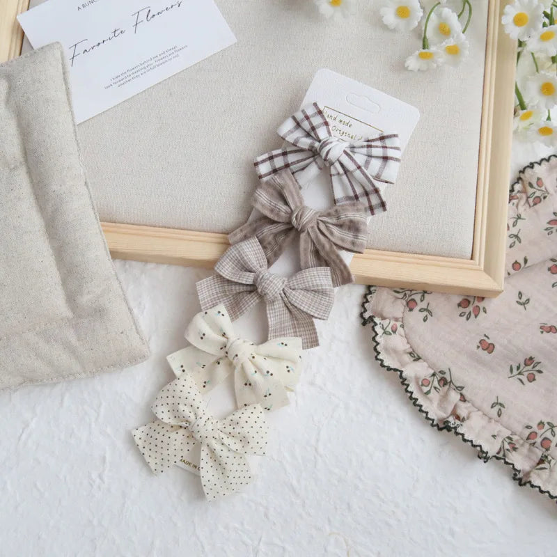 Set of four elegant cotton hair bows for girls in plaid, polka dot, and solid beige designs.