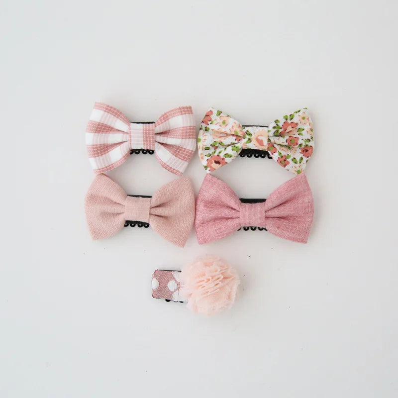 Set of five pink and white cotton baby hair clips with decorative bows and a pom-pom.