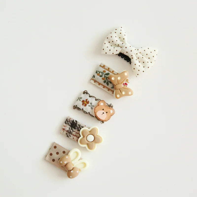 Set of five cute baby hair clips with decorative bows, a bear, a flower, and a bunny.