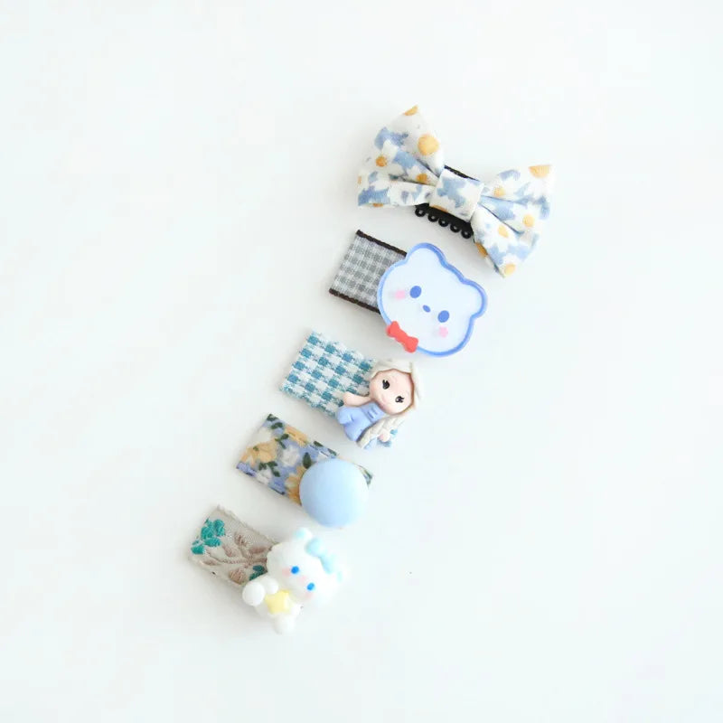 Set of five colorful baby hair clips with bows, floral prints, and cute character designs.