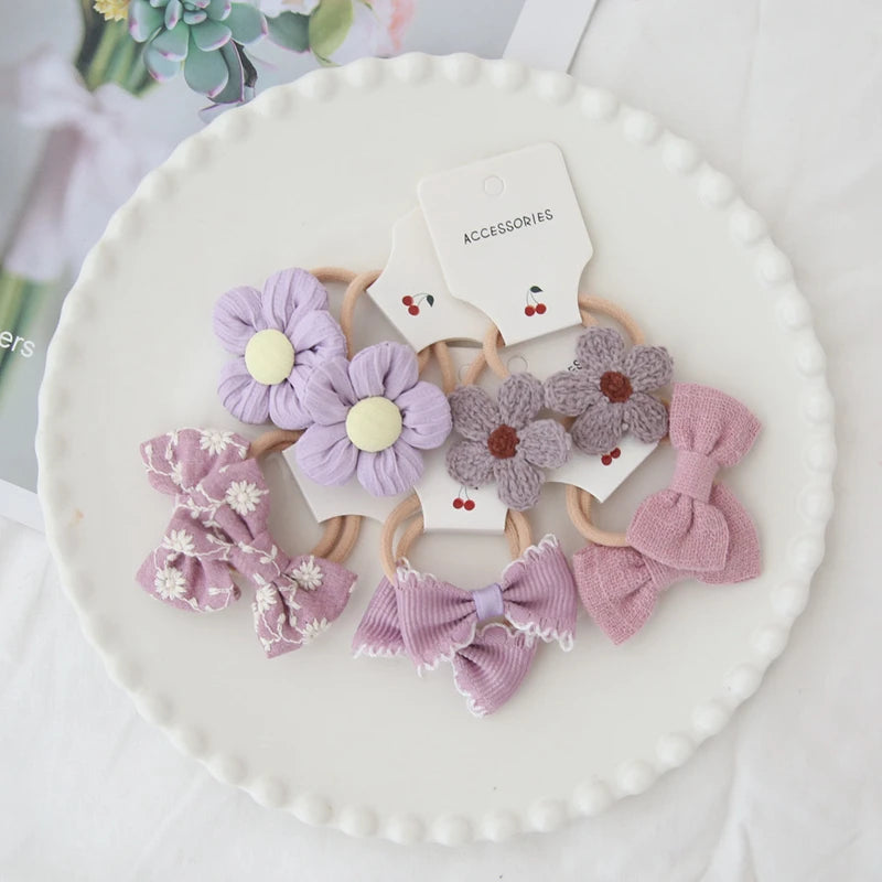 Handmade floral and bow hair ties for girls in shades of purple and pink, 10-pack.