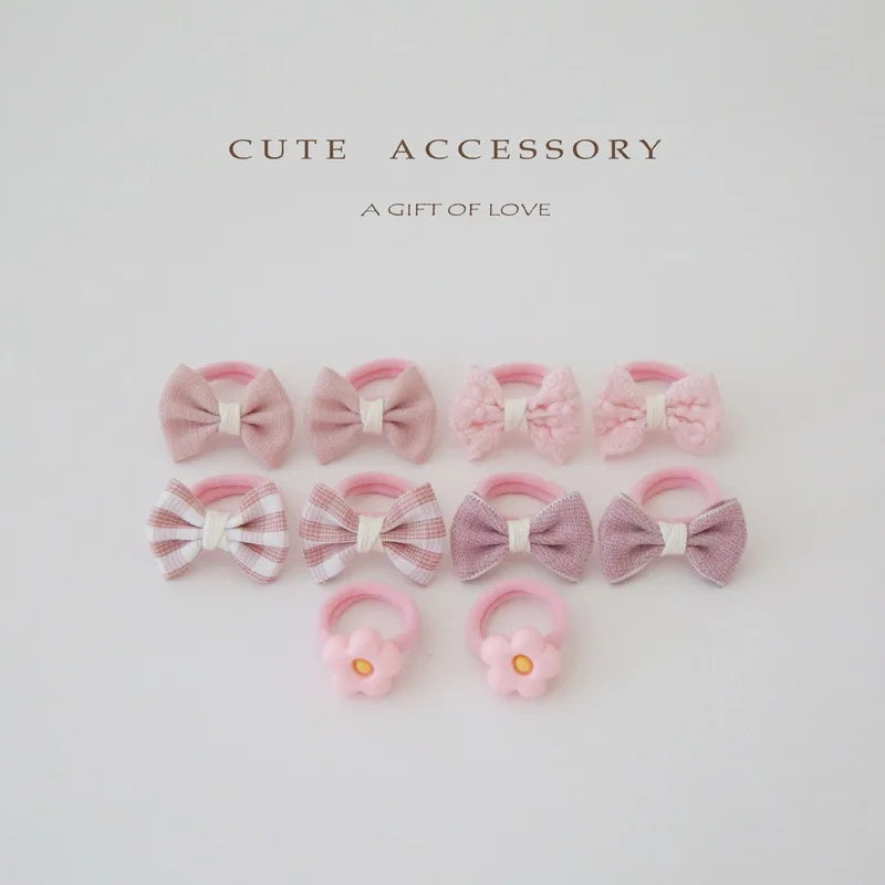Set of 10 pink cotton hair ties and clips for girls, featuring bows and flower designs.