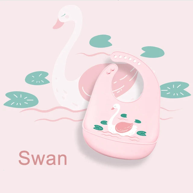 Pink silicone baby bib with a swan and lily pad design, waterproof and adjustable.