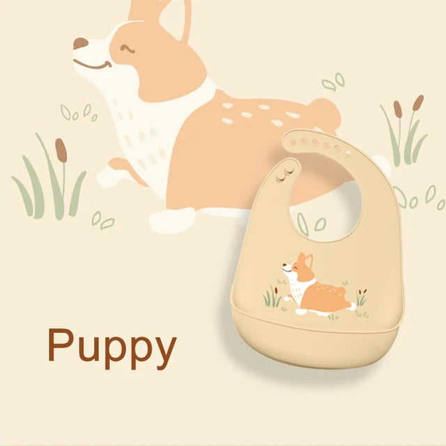 Adjustable beige silicone baby bib with a cute corgi puppy design and food-catching pocket.