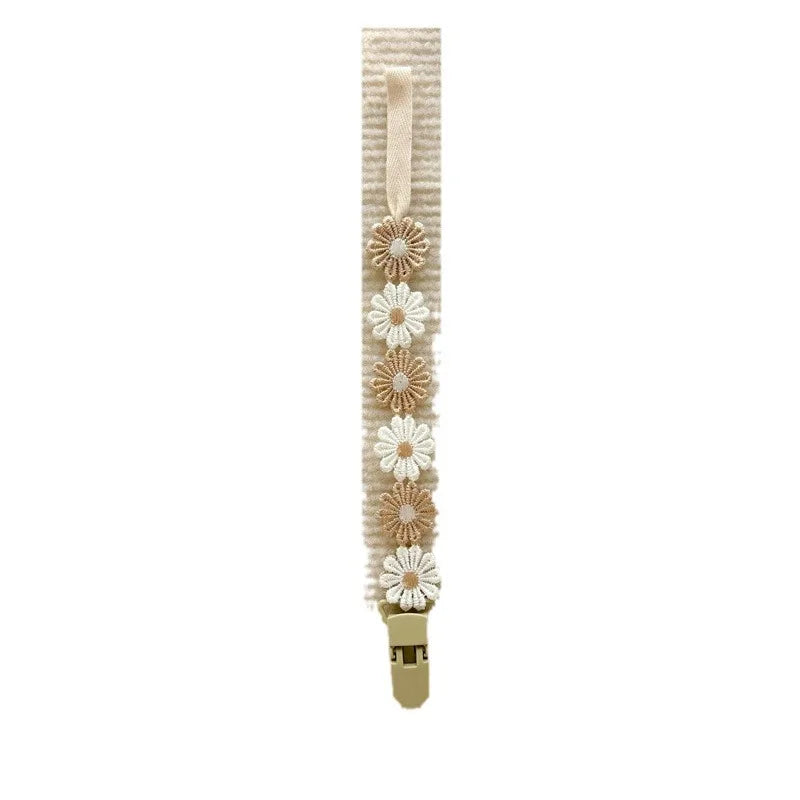 Beige polyester pacifier clip with alternating white and tan daisy flower embellishments.