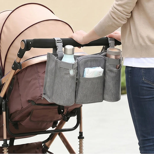 Gray waterproof stroller organizer bag with multiple compartments, holding bottles and diapers.