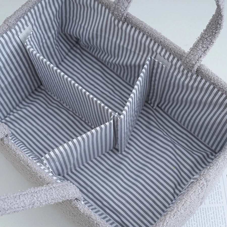 Gray portable baby diaper caddy organizer with striped interior dividers for bottles and essentials.