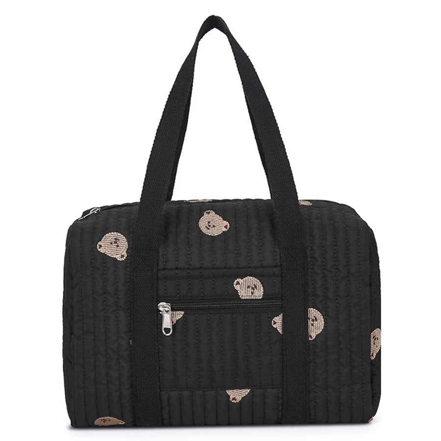 Black quilted diaper bag with brown bear print, front zipper pocket, and sturdy top handles.