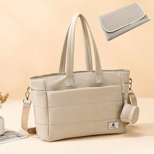 Beige quilted large capacity diaper tote bag with shoulder strap and matching changing pad.