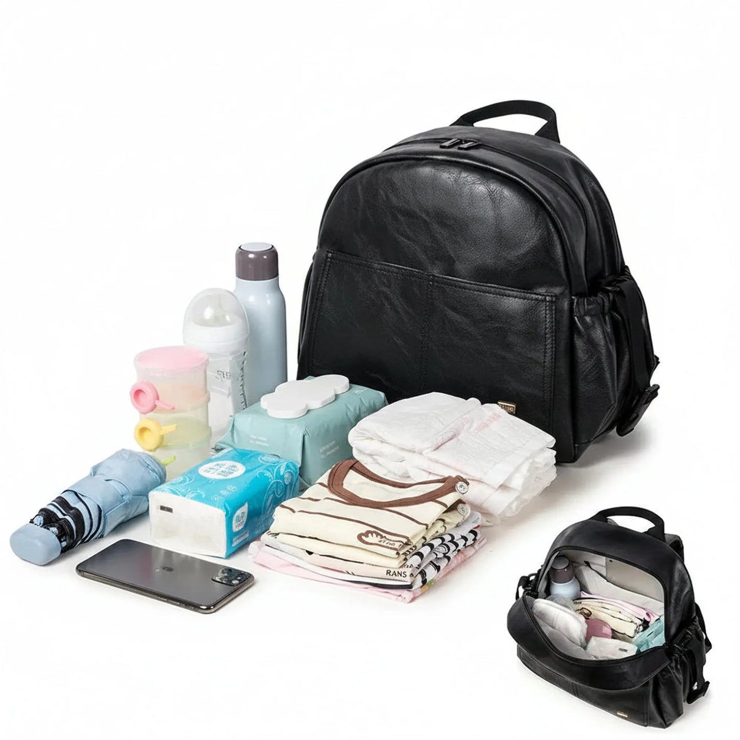 Black PU leather waterproof diaper backpack with large capacity, shown with baby essentials and a smaller open bag.