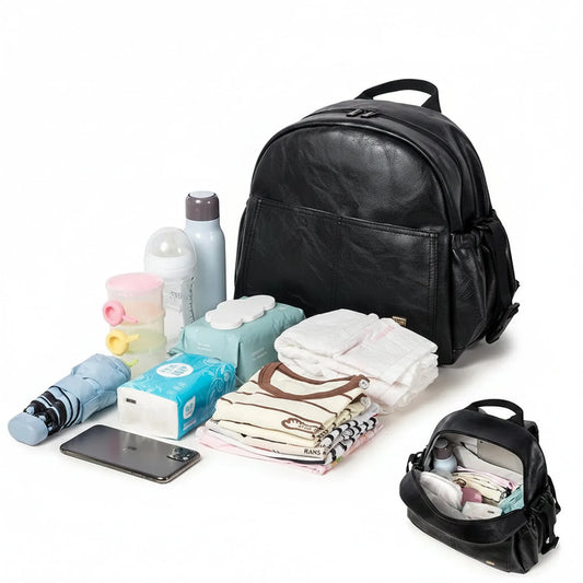 Black PU leather waterproof diaper backpack with large capacity, shown with baby essentials and a smaller open bag.