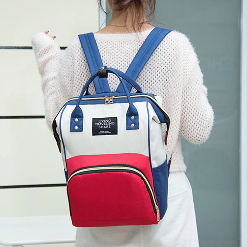 Multifunctional canvas diaper backpack in red, white, and blue with a thermal compartment.