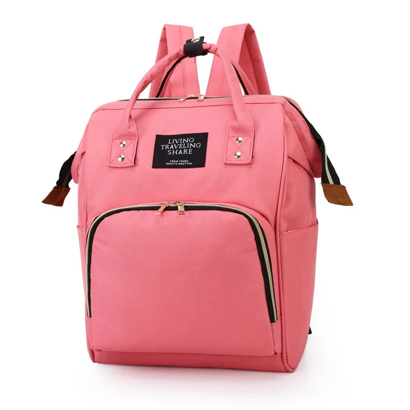 Pink canvas diaper backpack with thermal pocket, gold zippers, and top handles.