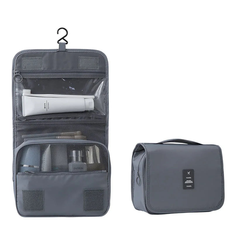 Gray waterproof hanging travel toiletry bag, open with compartments and closed with a handle.
