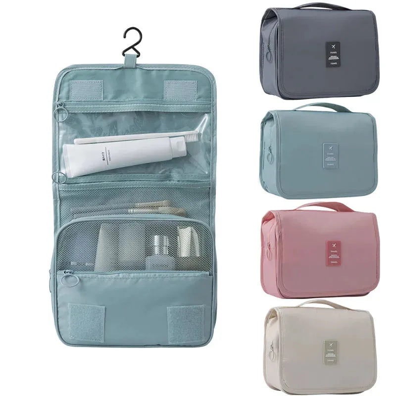 Hanging travel toiletry bag in light blue, open with compartments, alongside closed bags in gray, mint, pink, and beige.