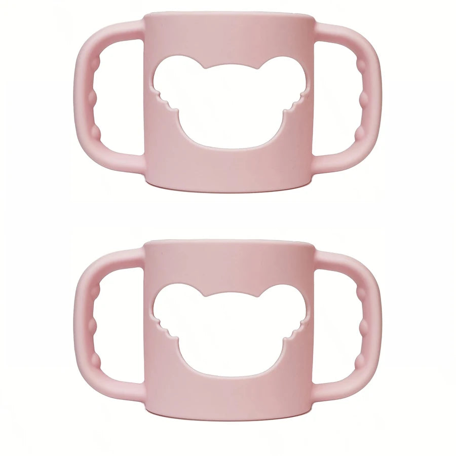 Two soft pink silicone baby bottle handles with a bear-shaped cutout, designed for easy grip.
