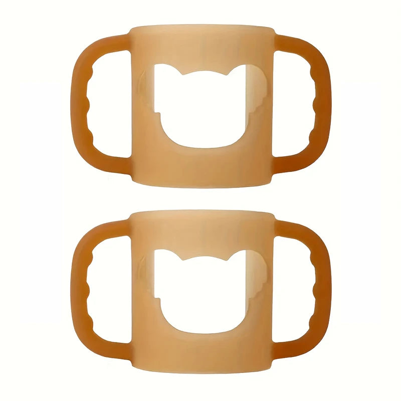 Two soft, flexible silicone baby bottle handles in a warm peach color, featuring a cute cat-shaped cutout.